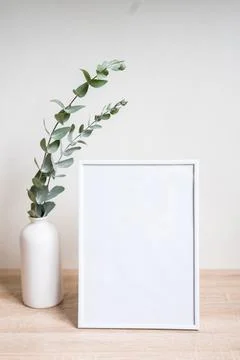 Minimalist home decor with empty frame mock-up on white wall background Stock Photos