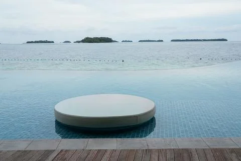 Minimalist Infinity Pool With Circular Platform and Tropical Sea View Stock Photos