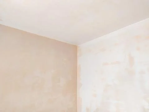 A minimalist interior corner featuring freshly plastered walls in progress... 写真素材