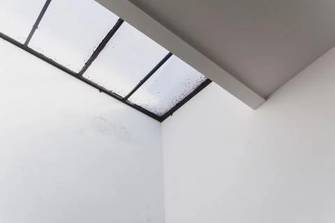 Minimalist interior corner with a skylight window and white walls Stock Photos