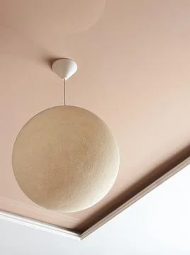 Minimalist interior design with ceiling lamp in the form of a wicker ball. Stock Photos