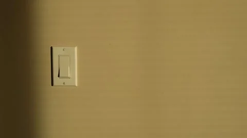 Minimalist Light Switch on a Beige Wall in Soft Light Stock Footage 263927807