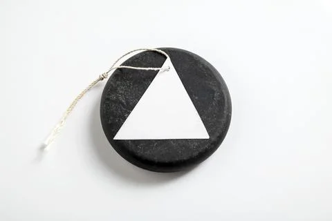 Minimalist mockup featuring a blank white triangular tag with string on a r.. Stock Photos