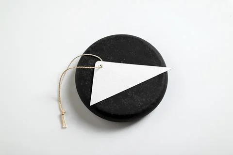 Minimalist mockup featuring a blank white triangular tag with string on a r.. Stock Photos