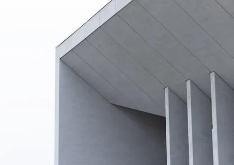 Minimalist modern building facade with angular gray panels and vertical fins. Stock Photos