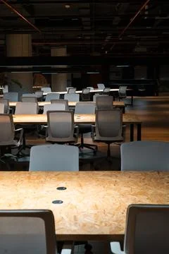 Minimalist office interior features empty tables and gray chairs Stock Photos