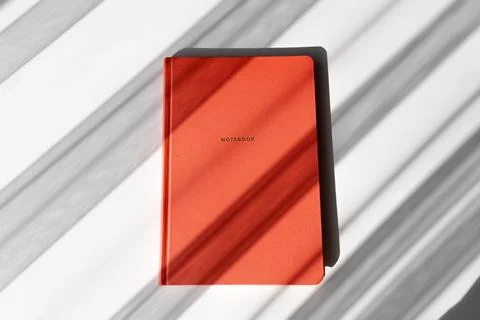Minimalist Red Notebook with Shadows on White Background for Study or Offic.. Foto stock