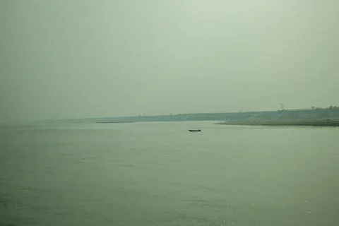 Minimalist river landscape featuring small boat on calm still water. Stock Photos