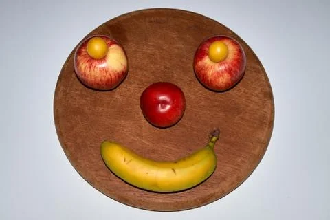 Minimalist round fruit face made of apple, peach and banana Stock-Fotos