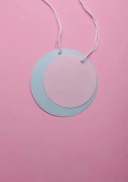 Minimalist round paper tags with string on pink background Stock Photos