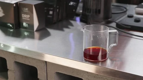 Minimalist shot of coffee server with steam in industrial roastery Stock Footage 334732448