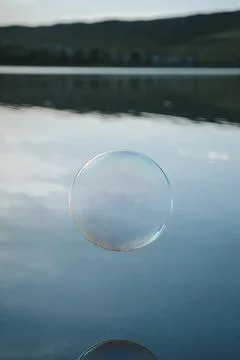 Minimalist Soap Bubble Floating Above Calm Lake Water Symbolizing Balance and Stock-Fotos