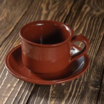 Minimalist styled empty coffee cup and saucer on a natural wooden table Stock Photos