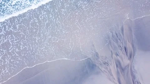 A minimalist top down drone video of waves on a sandy beach. Video stock 315612331