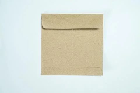 Minimalist top view of a closed square brown kraft paper envelope on a ligh.. Stock Photos