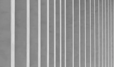 Minimalist vertical stripes on a gray wall. Repeating white lines create an Stock Photos