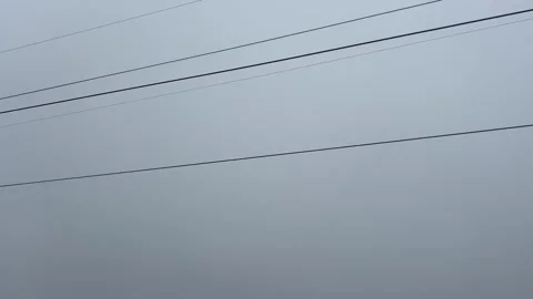 Minimalist View of Cable Car Lines and a Single Red Gondola in a Thick Foggy Sky Stock Footage 336797793