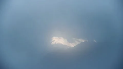 Minimalist view of a mountain ridge appearing in a thick bluish morning fog. Stock Footage 138816948