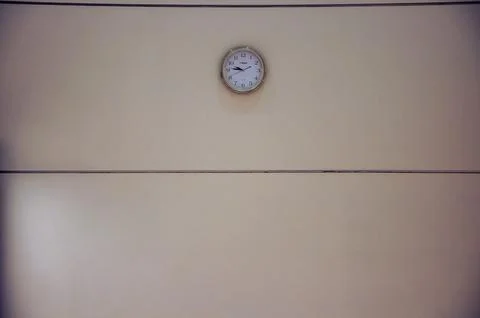 Minimalist wall with analog clock, evoking simplicity and timekeeping Фото