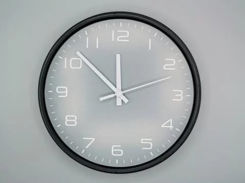 Minimalist wall clock on light gray wall Stock Photos