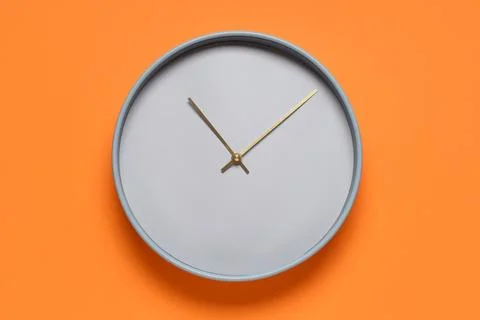 Minimalist wall clock on orange background Stock Photos