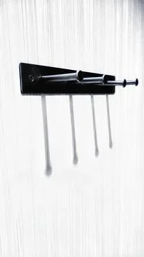 Minimalist Wall Hooks Casting Long Shadows on White Background Stock Photos