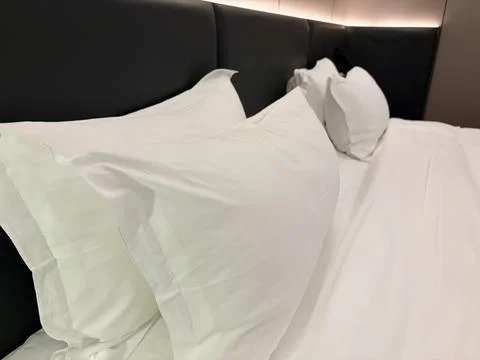 Minimalist White Bed with Soft Lighting Stock-Fotos