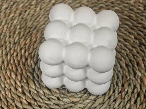 Minimalist White Bubble Ceramic Decorative Object on Natural Woven Basket Ba Fotos Stock