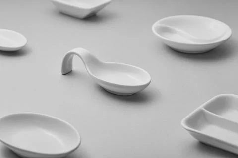 Minimalist white ceramic tableware is arranged on a gray surface Stock Photos