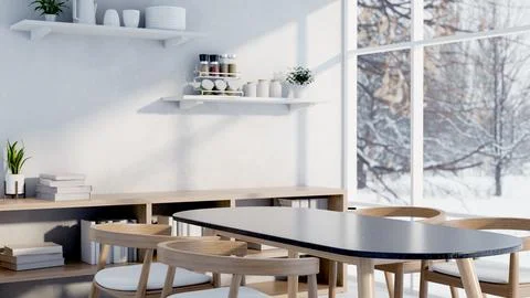 A minimalist white dining room featuring a simple dining table and a winter.. Stock Photos