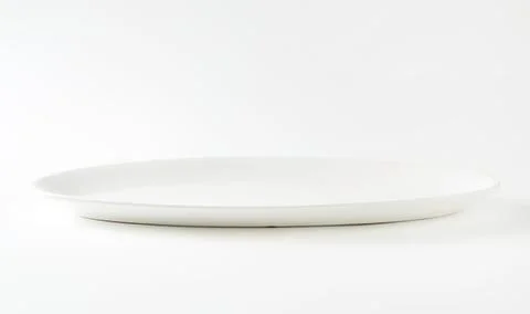 Minimalist white dinner plate on plain background Stock Photos