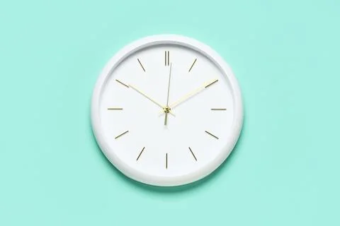 Minimalist white wall clock on turquoise background Stock Photos