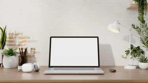 A minimalist workspace features a laptop computer mockup on a desk against .. Stock Photos