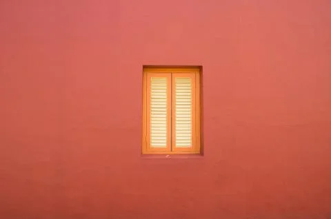 Minimalistic architecture background of orange window on red plaster wall Stock Photos