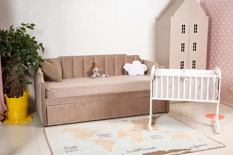 Minimalistic baby's room interior with an elegant child's bed and sofa for mo Stock Photos