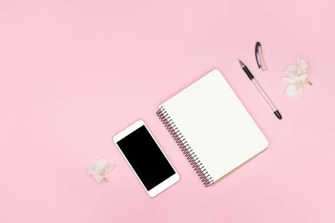 Minimalistic background. Notebook, pen, mobile phone on a pink background. Foto stock