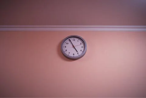 Minimalistic clock at blank wall interior background Foto stock