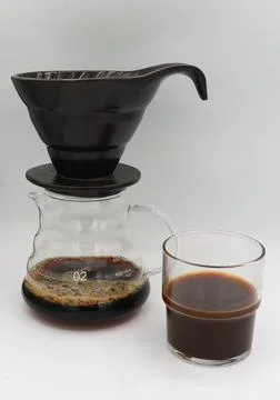 Minimalistic coffee brewing setup featuring a black dripper Stock Photos