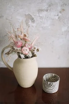 Minimalistic composition of dried flowers in ceramic vase as home decoration. Stock Photos
