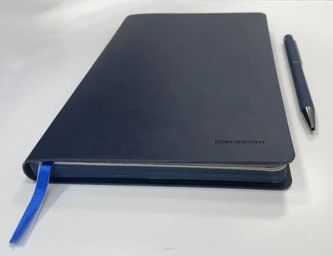 Minimalistic composition featuring a sleek navy blue notebook Stock Photos