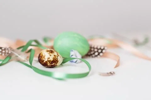 A minimalistic composition of ribbons and Easter eggs on a white table Stock Photos
