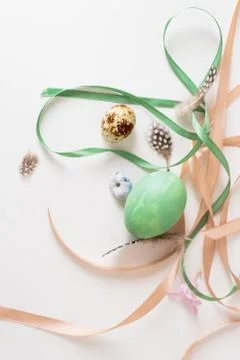 A minimalistic composition of ribbons and Easter eggs on a white table Stock Photos