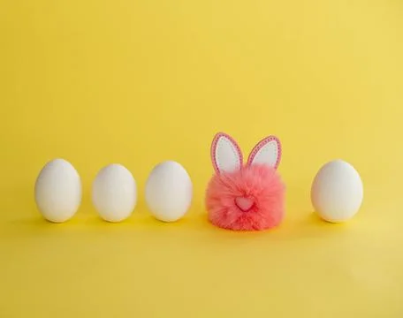 Minimalistic Easter composition. White eggs stand in a row, among them a pink Foto stock
