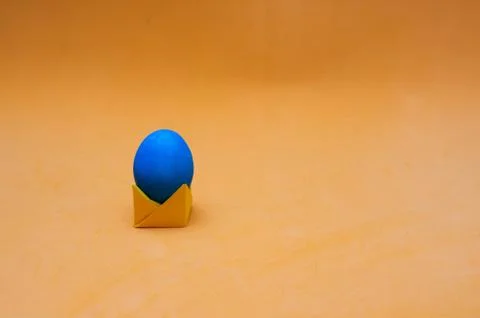 Minimalistic easter concept. Egg on origami stand. Place for text Stock Photos