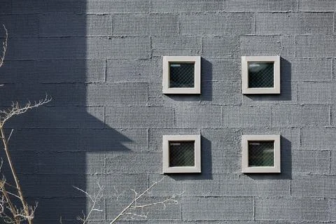 Minimalistic Gray Wall With Four Small Square Windows Foto stock