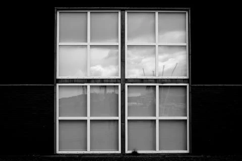 Minimalistic grayscale image of a symmetric window on a black wall - great for w Ilustración de archivo