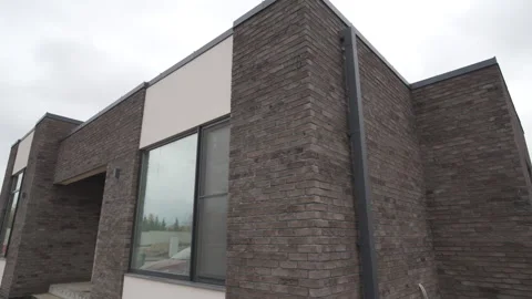 Minimalistic house with large window under cloudy sky Stockbeeldmateriaal 303107469
