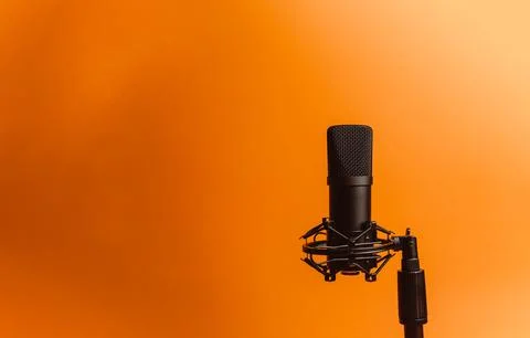 Minimalistic image of a streaming microphone over an orange background with.. Stock Photos