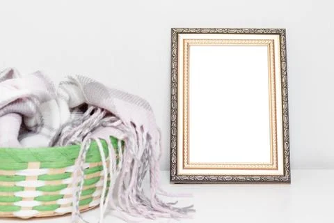 Minimalistic interior design with photo frame and a basket with warm woolen c Stock Photos