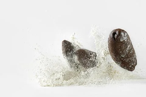 Minimalistic picture - rye bread falling into flour on a white background Stock Photos